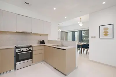 a kitchen with a sink and a stove top oven at Maison Privee - Modern Chic Apt with Unobstructed Burj Khalifa Views in Dubai