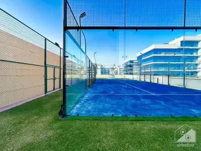 a tennis court with a net in a building at Modern & Chic studio with Balcony Dubai in Dubai