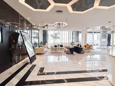 a lobby with couches and tables in a building at Modern & Chic studio with Balcony Dubai in Dubai