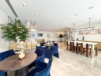 a restaurant with blue chairs and tables and a room with a bar at First Class Stay in Downtown Dubai Near Burj Park by SBH in Dubai