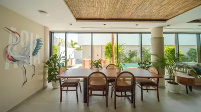 a dining room with a table and chairs and a pool at Nas House Private & Shared Villas in Dubai