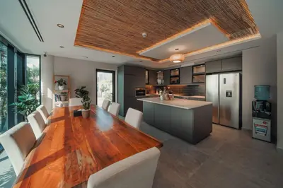a kitchen and dining room with a wooden table at Nas House Private & Shared Villas in Dubai
