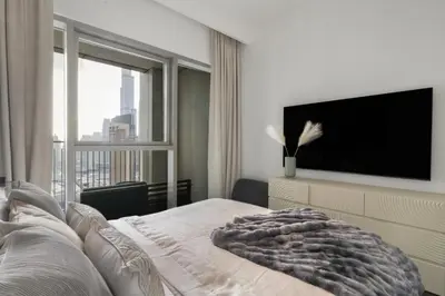 a bedroom with a flat screen tv and a bed at The Smart Concierge - Downtown views 2 in Dubai