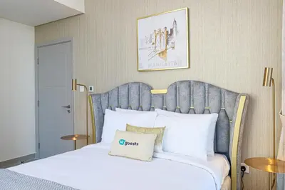 a bedroom with a white bed with a blue headboard at HiGuests - Tranquil Luxury 1BR Apt in the Heart of the City in Dubai