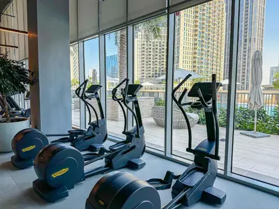 a row of treadmills in a gym with a large window at HiGuests - Tranquil Luxury 1BR Apt in the Heart of the City in Dubai