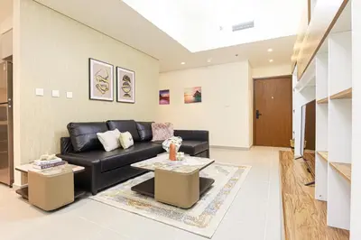 a living room with a black couch and a table at HiGuests - Tranquil Luxury 1BR Apt in the Heart of the City in Dubai
