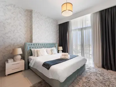 a bedroom with a bed and a large window at Modern Comforts -1 BR in Park Point- Dubai Hills in Dubai