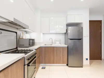 a kitchen with a stainless steel refrigerator and cabinets at Modern Comforts -1 BR in Park Point- Dubai Hills in Dubai