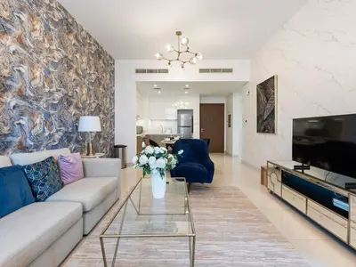 a living room with a couch and a tv at Modern Comforts -1 BR in Park Point- Dubai Hills in Dubai