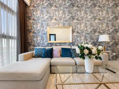 a living room with a couch and a vase of flowers at Modern Comforts -1 BR in Park Point- Dubai Hills in Dubai