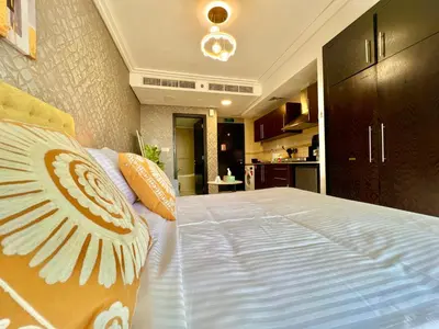 a bedroom with a large bed with orange pillows at Cosmos Living Cozy Studio GCV2 in Dubai