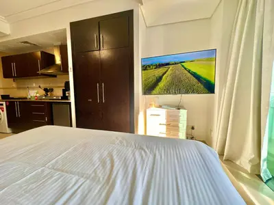 a bedroom with a bed and a painting on the wall at Cosmos Living Cozy Studio GCV2 in Dubai