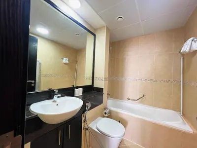 a bathroom with a sink and a toilet and a tub at Cosmos Living Cozy Studio GCV2 in Dubai
