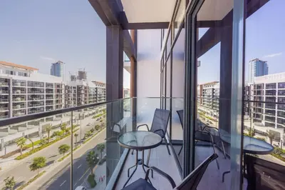 a balcony with tables and chairs and a view of a city at Urban Charm: Luxe 1BR Haven Near Downtown Dubai in Dubai