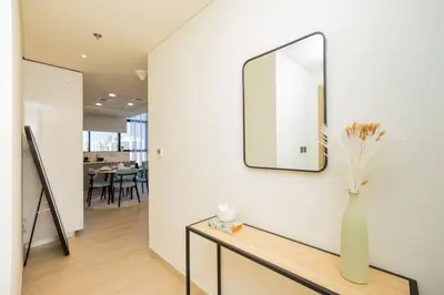 a vase on a table with a mirror on a wall at Urban Charm: Luxe 1BR Haven Near Downtown Dubai in Dubai