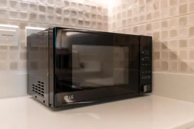 a black microwave oven sitting on top of a counter at The Seven Palm in Dubai