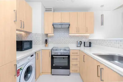 a kitchen with a stove and a dishwasher at The Seven Palm in Dubai