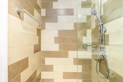 a bathroom with a shower with a glass door at The Seven Palm in Dubai