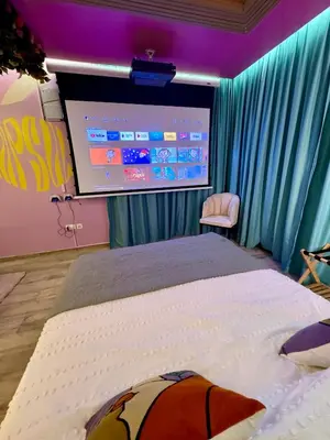 a bedroom with a bed and a projection screen at Capsule Flora business bay view Burj Khalifa-pool table-game arcade-Projector-Playstation 5 in Dubai