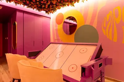 a dining room with a table and yellow chairs at Capsule Flora business bay view Burj Khalifa-pool table-game arcade-Projector-Playstation 5 in Dubai