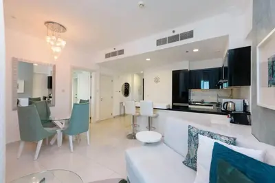 a kitchen and living room with a table and chairs at LUX 1 bed flat with Burj Khalifa View - 3 minute walk to Dubai Mall - Best Location - Best Balcony View in Dubai