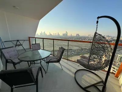 a balcony with a hammock and a table and chairs at Binghatti avenue in Dubai