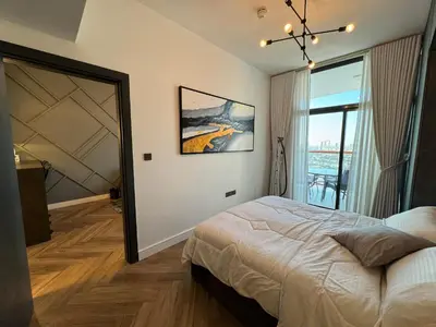 a bedroom with a bed and a large window at Binghatti avenue in Dubai