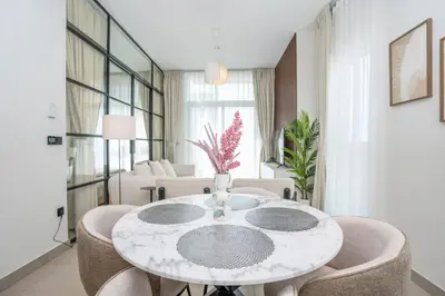 a white dining room with a table and chairs at Homesgetaway Luxury 2BR at Socio Dubai hills in Dubai