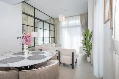 a white living room with a table and chairs at Homesgetaway Luxury 2BR at Socio Dubai hills in Dubai