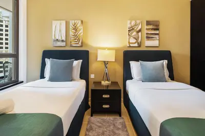 two beds sitting next to each other in a room at Spacious, Deluxe, 5BR plus maidroom on JBR walk Next to Beach ,Tram & Mall by La Buena Vida Holiday Homes in Dubai
