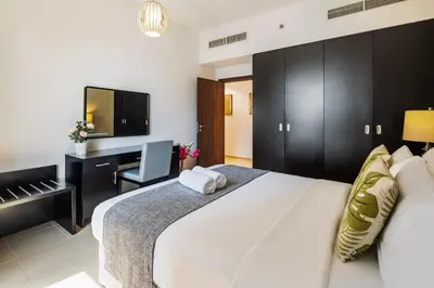 a bedroom with a bed and a desk and a television at Spacious, Deluxe, 5BR plus maidroom on JBR walk Next to Beach ,Tram & Mall by La Buena Vida Holiday Homes in Dubai