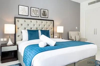a bedroom with a large bed with a blue blanket at Gorgeous Studio Apartment in DAMAC Celestia B Dubai South by Deluxe Holiday Homes in Dubai