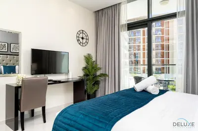 a bedroom with a bed and a desk and a tv at Gorgeous Studio Apartment in DAMAC Celestia B Dubai South by Deluxe Holiday Homes in Dubai