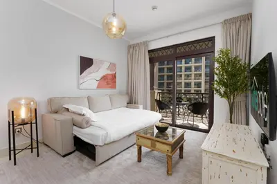 a living room with a white couch and a window at Green living chic 1 bedroom apartment in Dubai