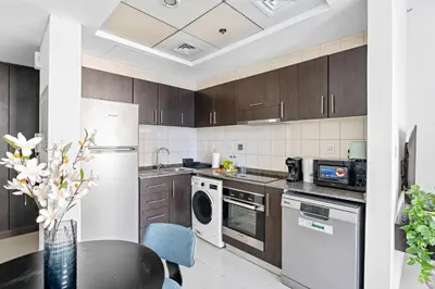 a kitchen with a white refrigerator and a table at Silkhaus Studio at Dubai Marina Near Marina Mall in Dubai