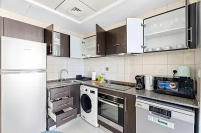 a kitchen with a refrigerator and a dishwasher at Silkhaus Studio at Dubai Marina Near Marina Mall in Dubai