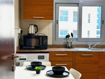 a kitchen with a table with two bowls on it at WOW Studio w/ Balcony and Canal View in Marina in Dubai