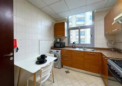 a small kitchen with a table and a sink at WOW Studio w/ Balcony and Canal View in Marina in Dubai