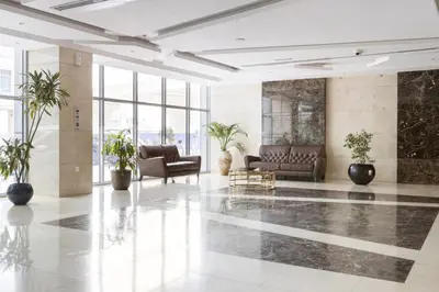 a lobby with couches and plants in a building at WOW Studio w/ Balcony and Canal View in Marina in Dubai