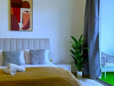a bedroom with a bed with yellow sheets and a plant at WOW Studio w/ Balcony and Canal View in Marina in Dubai