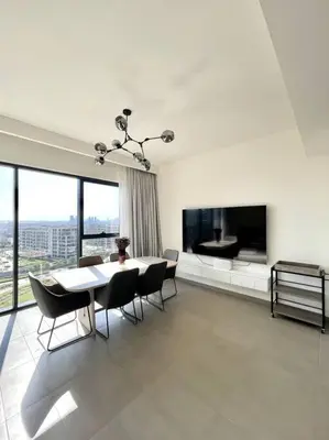 a living room with a table and chairs and a television at 3 bedrooms + maids room, Full Park view in Dubai