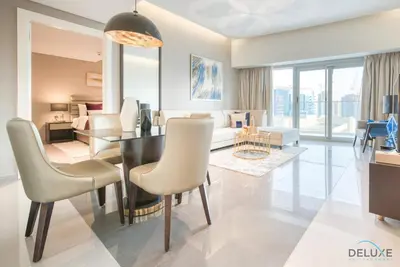 a living room with a dining table and a living room at Overlooking Canal Views, Fam-Friendly 2BR Unit, Damac Majestine Tower, Business Bay by Deluxe Holiday Homes in Dubai