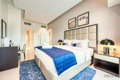 a bedroom with a large bed with a blue blanket at Overlooking Canal Views, Fam-Friendly 2BR Unit, Damac Majestine Tower, Business Bay by Deluxe Holiday Homes in Dubai
