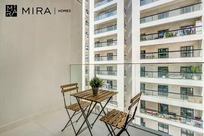 a table and chairs in a room with a building at Mira Holiday Homes-Cozy studio close to metro in Dubai