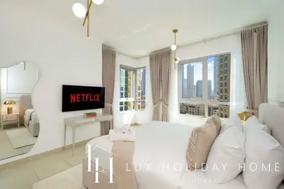 a bedroom with a white bed and a large window at LUX The Stunning Fountain View Suite in Dubai