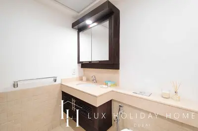 a bathroom with a sink and a mirror at LUX The Stunning Fountain View Suite in Dubai