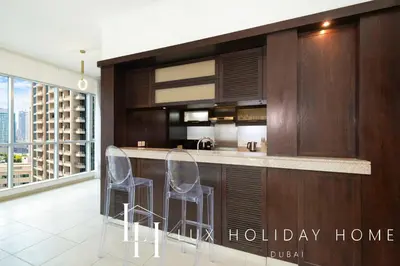 a kitchen with two stools at a kitchen counter at LUX The Stunning Fountain View Suite in Dubai