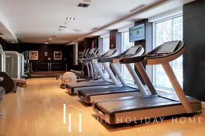 a gym with a row of treadles in a room at LUX The Stunning Fountain View Suite in Dubai