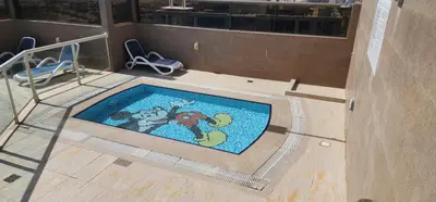 an indoor swimming pool with a mosaics in a building at Elite 6 Residence - Sports City by Golden Casa in Dubai