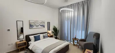 a bedroom with a bed and a chair in it at Shaista Azizi Residence - Al Furjan by Golden Casa in Dubai